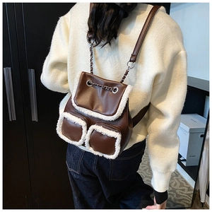 Detalle de mochila vintage de cuero PU marrón con ribete de piel sintética blanca y cadena