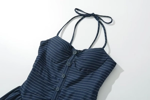 Détail de la robe licou à rayures bleu marine montrant les boutons et la texture
