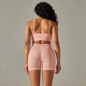 Detail of pink seamless yoga set featuring a cross-back sports bra and scrunch butt shorts