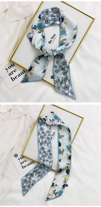 Detail of floral printed silk scarf in light blue with orange and navy floral patterns