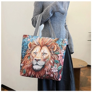 Close-up of 3D embroidered lion head pattern on canvas tote bag with woven texture