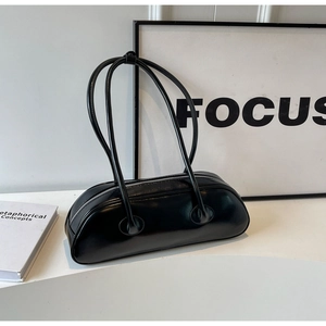 Detail of a black leather underarm bag with double slim shoulder straps and zipper closure
