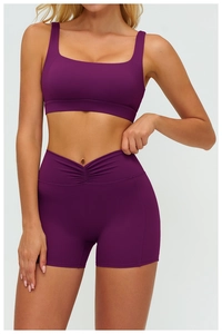 Detail of high-waisted yoga shorts with V-cross waistband and pleated lifting design