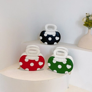 Mushroom-shaped polka dot handbags in black, red, and green with chain straps