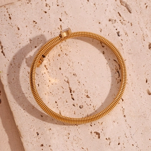 Detail of 18K gold-plated striped bangle featuring heart-shaped zircon on stone texture