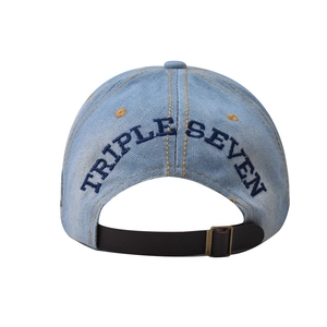 Dettaglio del berretto da baseball in denim azzurro con ricamo Triple Seven sul retro