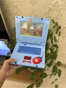 Handheld view of a blue toy laptop for kids featuring animal screen and red wired mouse