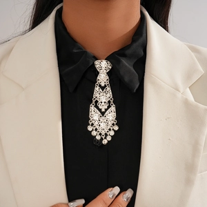 Macro shot of silver tassel necklace with rhinestones on black shirt and white blazer