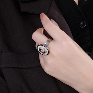Detailed view of silver stainless steel ring with zircon accents and black enamel frame