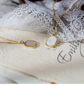 Detailed view of two 18K gold plated necklaces with rectangular mother of pearl pendants
