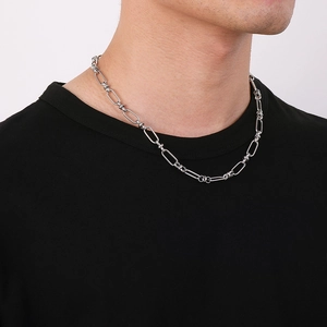 Close-up of polished silver paperclip chain necklace worn on a black t-shirt