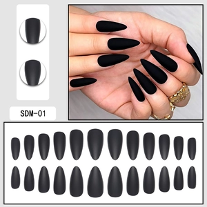 Close-up of matte black almond press-on nails set with size chart and textured detail