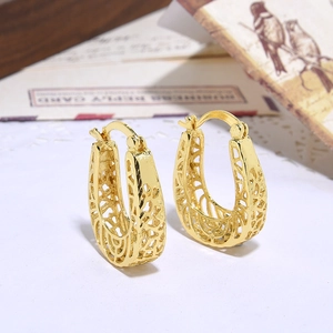 Macro view of vintage gold hollow-out earrings on aesthetic background