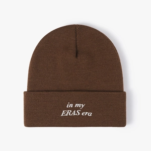 Dark brown knit beanie with white in my ERAS era embroidery for winter warmth
