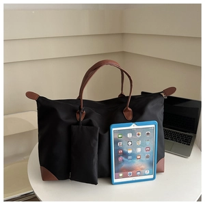 Detail view of large waterproof oxford tote bag with leather straps and a small side pouch