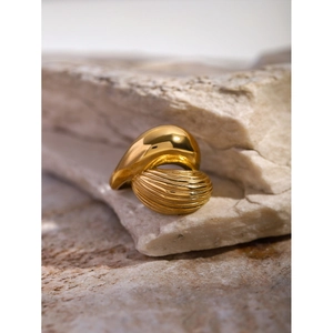 Detailed view of golden teardrop ring featuring twisted smooth and textured metal finishes