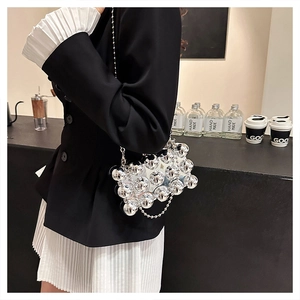 Detailed view of a silver spherical beaded box bag with metallic finish and chain strap