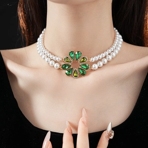 Primo piano della collana di perle a doppio strato con ciondolo a fiore verde indossata