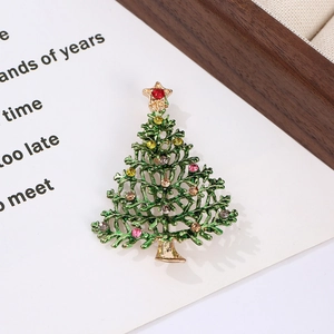 Detailed close-up of a Christmas tree brooch with colorful rhinestones on green enamel