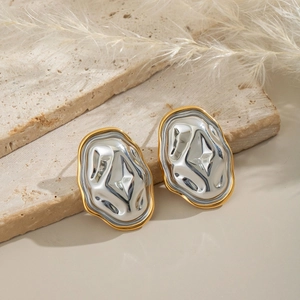 Boucles d'oreilles géométriques modernes en or et argent sur un support en pierre