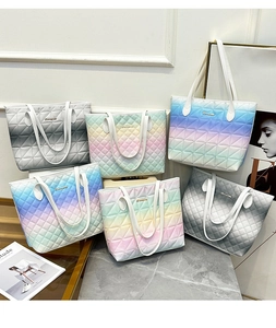 Collection of quilted tote bags featuring colorful gradient patterns on a marble surface