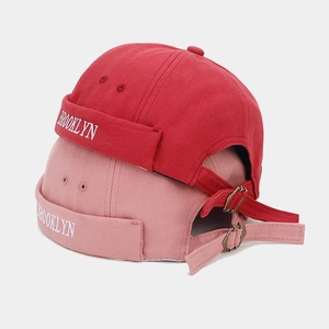 Detail of red and pink docker caps with Brooklyn embroidery and metal buckle strap