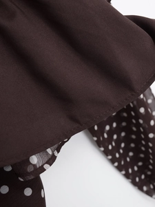 Detail of dark brown fabric with white polka dots and high-quality stitching texture