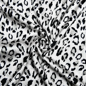 Vue macro du tissu léopard en soie montrant la texture satinée et le drapé élégant