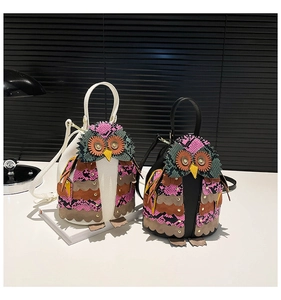 Detail of owl-shaped handbags featuring multi-colored patchwork and snakeskin texture