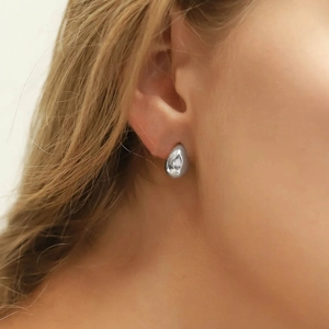 Detailed view of silver C-shaped star earring with round zircon inlay on person
