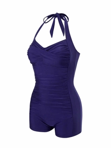 Detail of ruched tummy control swimsuit with halter neck and boyleg cut in dark purple