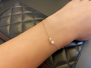 Detailed macro shot of an 18K gold-plated silver bracelet with pearl and zircon stone