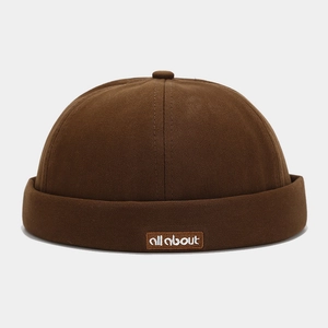 Close-up of a dark brown Miki Hat showing twill texture and 'all about' embroidery