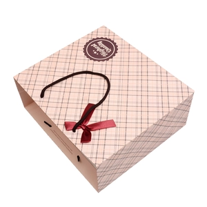 Pink plaid gift bag featuring a dark red bow and brown rope handles with quality seal