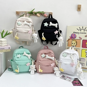 Close-up of five mini cat-themed nylon backpacks in pastel colors with cute plush charms