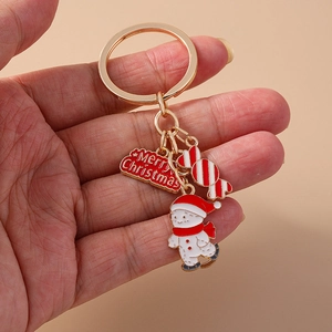 Close-up of Christmas keychain with snowman, candy cane, and Merry Christmas charms