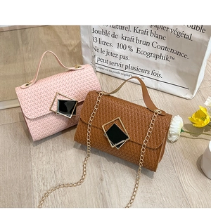 Detalle de mini bolsos rosa y marrón con textura trenzada y cadena dorada