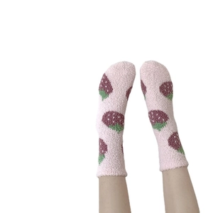 Pink coral fleece strawberry mid-tube warm socks for women shown on a white background