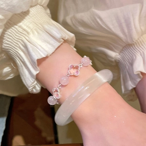 Detail view of pink clover beaded bracelet paired with translucent white agate bangle