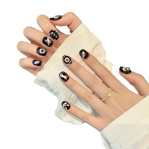Halloween press-on nails with hand-painted skull bones and eyeballs on black glossy base