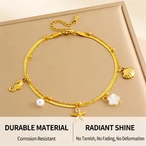 Detail einer goldenen geschichteten Fußkette mit Seepferdchen und Seestern-Anhängern