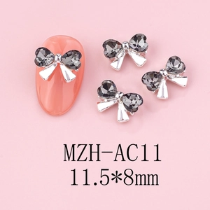 Detail view of silver bow nail art charm with grey heart rhinestone, size 11.5x8mm