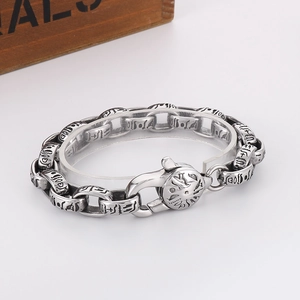 Macro view of vintage silver steel bracelet showing engraved symbols and chunky chain