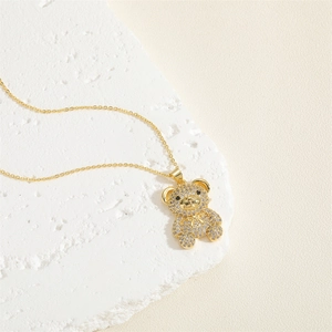 Macro detail of golden bear pendant necklace with pave-set sparkling zircon crystals