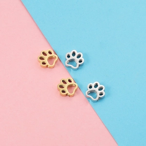 Cute gold and silver paw print charms for DIY necklaces and bracelets on pink blue background