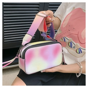 Detail of colorful gradient camera bag with wide strap worn by model on shoulder