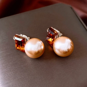 Détail macro de boucles d'oreilles vintage avec cristaux ambrés et perles dorées