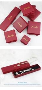 Detailed view of red jewelry gift boxes with gold text and elegant bow decoration