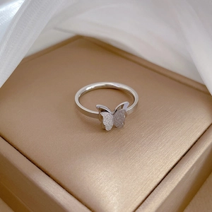 Detailed view of silver butterfly ring featuring frosted finish and polished metal edges
