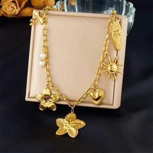 Detailed view of gold plated chain necklace with heart and flower charms on a display
